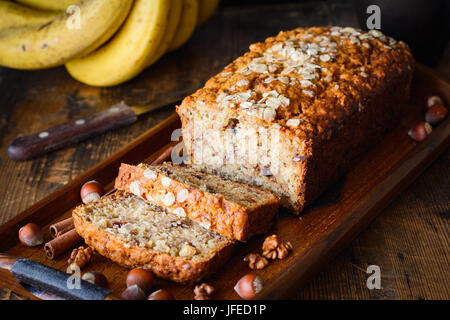 Bananenbrot mit Walnüssen, Zimt und Schokolade-Chips auf Tablett aus Holz. Nahaufnahme, selektiven Fokus Stockfoto