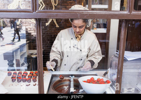 England, London, Covent Garden, Godiva Store, Frau, die Herstellung von Schokolade getaucht Erdbeeren Stockfoto