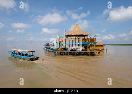 Boot direkt neben einem Gebäude auf einem schwimmenden Dorf im Mekong, Kambodscha Stockfoto