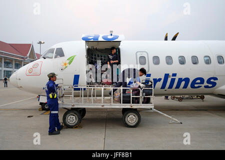 Beutel handler Gepäck laden in Lao Airlines Flugzeug am Flughafen Asphalt Stockfoto