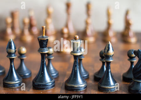 Alte hölzerne Schachfiguren auf einem alten Schachbrett. Stockfoto