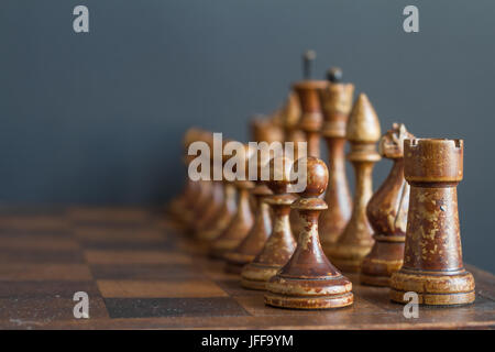 Alte hölzerne Schachfiguren auf einem alten Schachbrett. Stockfoto