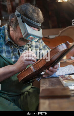 Geigenbauer mit Vergrößerung für Malerei-Violine Stockfoto