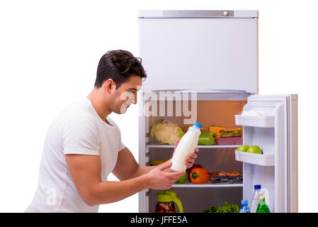 Mann neben Kühlschrank voller Lebensmittel Stockfoto