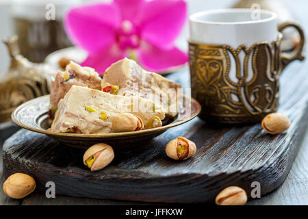 Tahini halva mit Pistazien auf einer Bronzetafel. Stockfoto