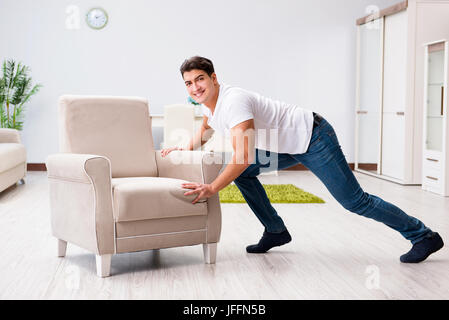 Junger Mann bewegliche Möbel zu Hause Stockfoto