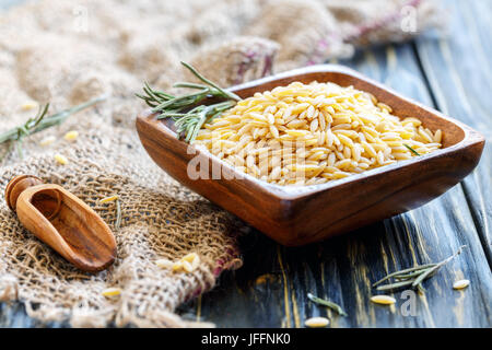 Italienische Pasta orzo in eine hölzerne Schüssel. Stockfoto