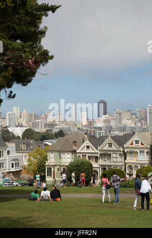 Menschen versammelten sich in einem Park in der Innenstadt von San Francisco in der Nähe der berühmten Häuserreihe der Painted Ladies genannt. Stockfoto