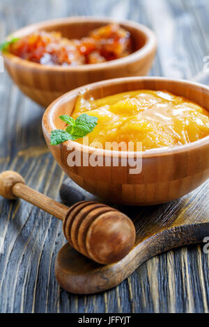 Hölzerne Schüssel mit Honig und Honig Pendelarm. Stockfoto