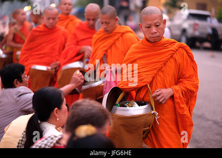 Prozession der buddhistischen Mönche tragen orangefarbene Gewänder in der Morgendämmerung Geschenke auf den Straßen von Luang Prabang, Laos, Asien zu sammeln Stockfoto