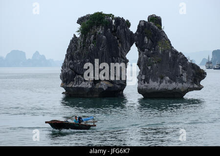 Angeln Boot vorbei Küssen Felsen Felsformation in der Halong Bay, Vietnam, Asien Stockfoto