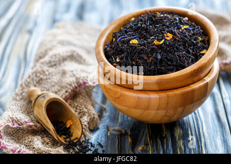 Schwarzer Tee mit Bergamotte in einem hölzernen Schüsseln. Stockfoto