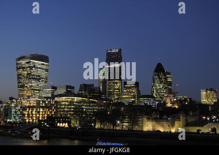 Die moderne Skyline der City of London mit dem Walkie Talkie Building, The Gherkin, The Cheesegrater und Tower of London in der Nacht, London, England Stockfoto