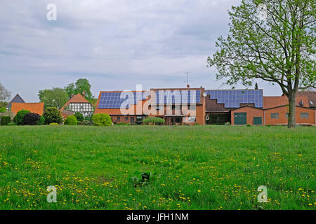 modernes Backsteingebäude mit Solarzellen neben einem traditionellen Fachwerkhaus in Hävern, Kreis Minden-Lübbecke, North Rhine-Westphalia, Deutschland Stockfoto