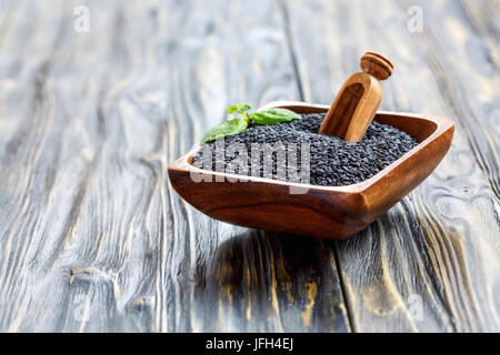 Schwarze Sesamsamen in eine hölzerne Schüssel. Stockfoto