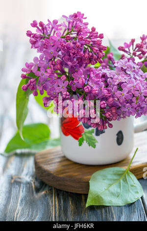 Flieder in einem alten Emaille Tasse. Stockfoto