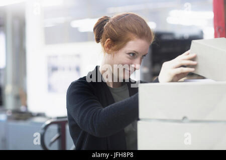 Attraktive Arbeitnehmerin Öffnung Box am Presse Stockfoto