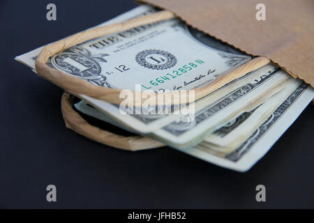 US-Dollar in eine braune Papiertüte. Stockfoto