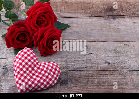 Herzen und einen Strauß roter Rosen auf Holzbrett, Tag Hintergrund der Mutter Stockfoto