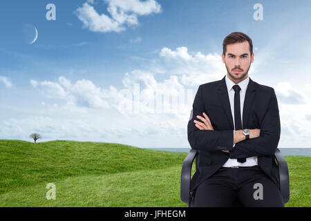 Zusammengesetztes Bild des ernsthaften Geschäftsmann sitzen mit verschränkten Armen Stockfoto