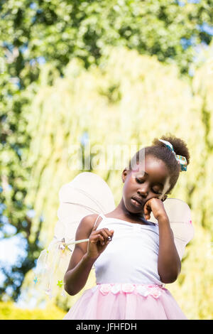 Niedliche Mischenrennen Mädchen langweilig und eine Fee Kleid Stockfoto