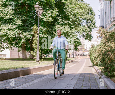 Geschäftsmann Reiten Fahrrad an städtischen Straße morgen arbeiten. Lifestyle, Transport, Kommunikation und Menschen Konzept, Stockfoto