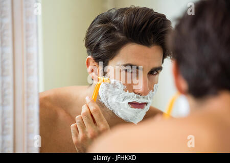 Mann reflektieren, Spiegel während der Rasur seinen Bart Stockfoto