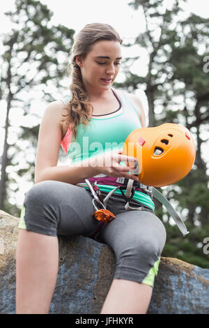 Low Angle View junge Frau sitzt auf Felsen Stockfoto