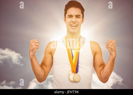 Zusammengesetztes Bild des Athleten posiert mit Goldmedaille nach Sieg Stockfoto