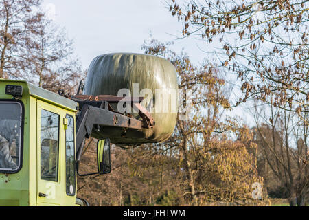 Ballen Heu Transport mit einem alten Bauernhof. Stockfoto