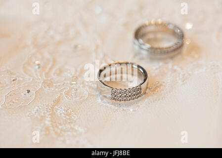 Hochzeit Ringe aus Platin mit Diamanten auf einem Hintergrund von lacy gemacht Stockfoto