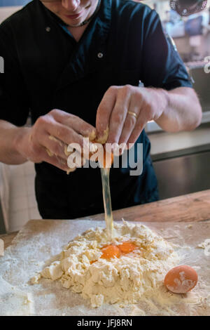 Der Koch arbeitet mit Händen den Pizzateig Mehl und frischen Eiern Italien Stockfoto