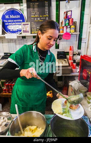 England, London, Southwark, Manze Pie und Mash-Shop, Assistent Mahlzeit von Pie und Mash und Schnaps Stockfoto