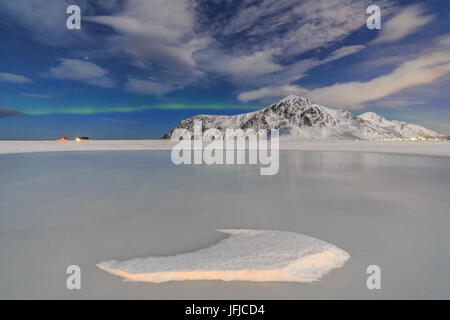 Nordlichter auf dem zugefrorenen Meer und Schnee bedeckt Berge, Flakstad Lofoten Inseln Norwegen Nordeuropa Stockfoto