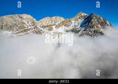 Die Feuchtigkeit der Wolken und der Schatten des Hubschraubers erstellen Brocken Gespenst in Europa, der Schweiz, Zermatt Stockfoto