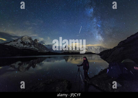 Fotografen unter Sternenhimmel und Milchstraße reflektiert am Lac de Cheserys Chamonix Haute Savoie Frankreich Europa Stockfoto