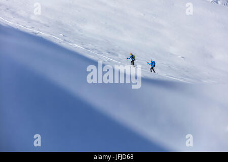 Alpin-Skifahrer fahren Sie in großer Höhe an einem sonnigen Tag in der verschneiten Landschaft Stelvio Pass Valtellina Lombardei Italien Europa Stockfoto