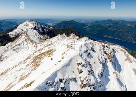 Luftaufnahme der schneebedeckten Gipfel der Grignone Brioschi Zuflucht auf der Oberseite und See im Hintergrund Lecco Provinz Lombardei Italien Europa Stockfoto