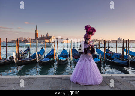 Venedig, Veneto, Italien, eine traditionelle Maske Venedig Karneval mit St-George-Insel und einige Gondeln im Hintergrund bei Sonnenuntergang, Stockfoto