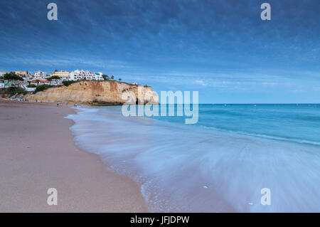 Ozean-Wellen, die auf Felsen und Strand rund um Carvoeiro Dorf bei Sonnenuntergang Lagoa Gemeinde Algarve Portugal Europa Stockfoto