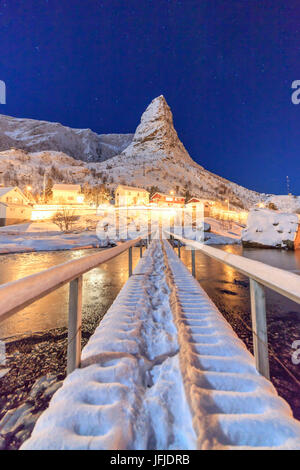 Sternenklare Nacht auf den schneebedeckten Gipfeln umgeben das gefrorene Meer Reinevagen Bay Nordland Lofoten Inseln Norwegen Europa Stockfoto