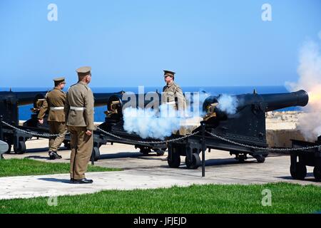 Soldaten schießen Kanonen für die Mittagszeit Waffe in Upper Barrakka Gardens, Valletta, Malta, Europa. Stockfoto