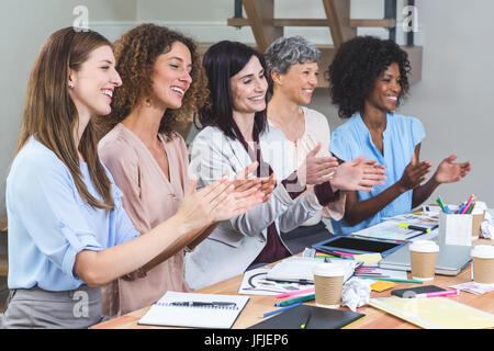 Gruppe von Innenarchitekten applaudieren im Büro Stockfoto