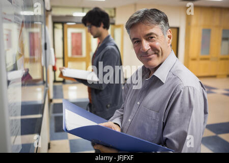 Porträt von lächelnden Professor stand vor schwarzen Brett Stockfoto