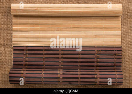 Zwei Bambusmatte verdreht in Form eines Manuskripts auf Sackleinen, mit Platz für Ihren text Stockfoto