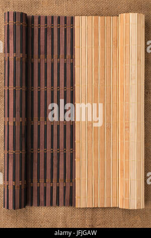 Zwei Bambusmatte verdreht in Form eines Manuskripts auf Sackleinen, mit Platz für Ihren text Stockfoto