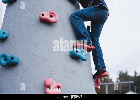 Ein Junge klettert Spielgeräte. Stockfoto