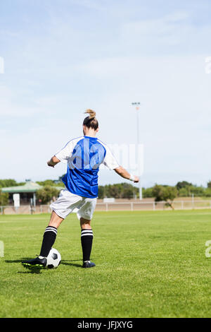 Rückansicht des weiblichen Fußballspieler üben Fußball Stockfoto