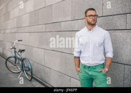 Voller Länge hübschen jungen Geschäftsmann mit seinem Fahrrad. Stockfoto