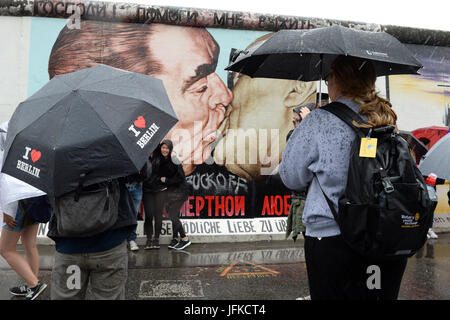 Berlin, Deutschland. 1. Juli 2017. Touristen tragen Regenschirme bei Regen an der East Sidie Gallery in Berlin, Deutschland, 1. Juli 2017. Foto: Maurizio Gambarini/Dpa/Alamy Live News Stockfoto